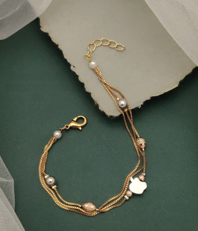 Jewels Galore Gold Plated Multi Strand Charm Bracelet Featuring Clover Motifs And Faux Pearls